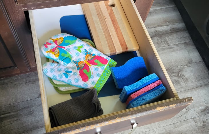 Kitchen drawers with cutting board, oven mitts, sponges