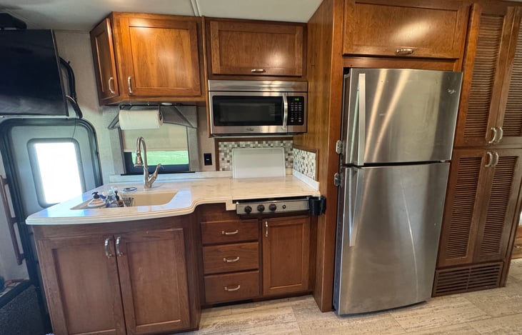 Full size fridge, microwave & 4 burner stovetop with cover for easy food prep.  Coffee Pot and Toaster included.  We use upper cabinet next to fridge for panty and lower cabinet for extra closet space