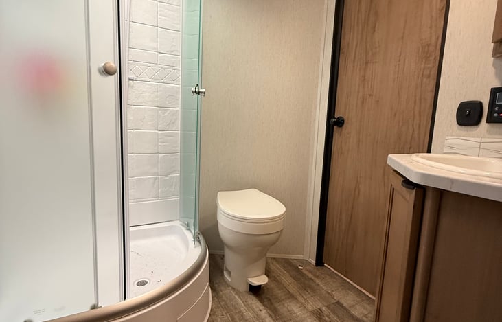 Bathroom shot. Big(ger) clean shower, single vanity with a door to hallway, door to master and exterior glass door to outside.