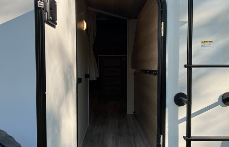 Bottom bunk folds up with large door for oversize storage items like kayaks and bikes.