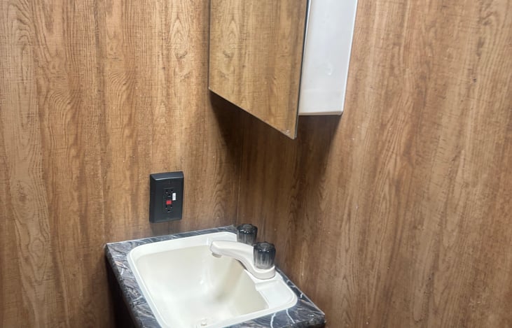 Compact Bathroom Vanity – Includes a built-in sink with hot/cold knobs, a stylish countertop, and a mirrored medicine cabinet above for convenient storage.