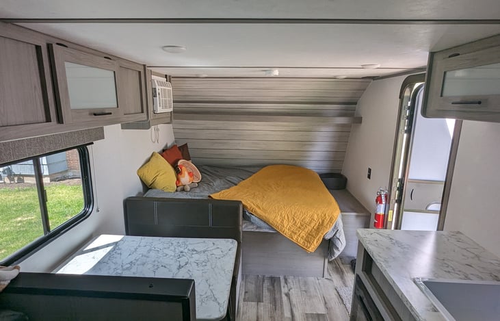 Cozy queen size bed (short queen) with upgraded memory foam mattress, dinette that converts to a single bed, overhead storage nearly everywhere.