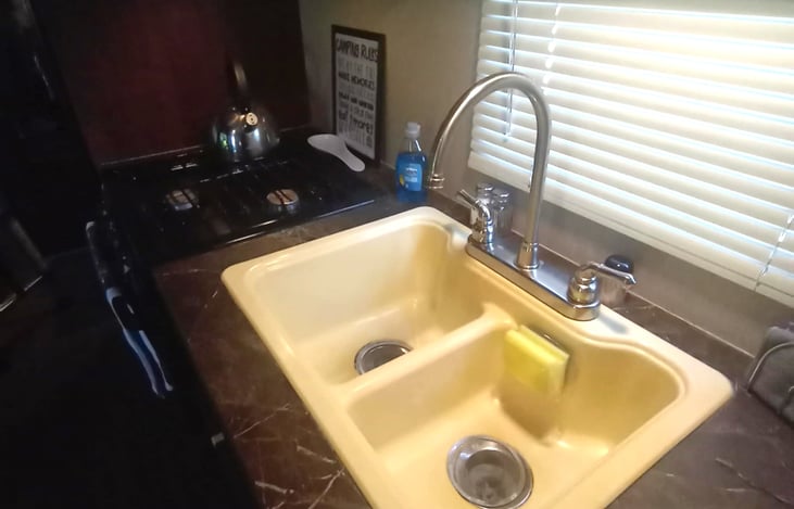 Kitchen is equipped with a large refrigerator lamp; freezer, microwave, 3 burner stove/oven and 50/50 deep sink.