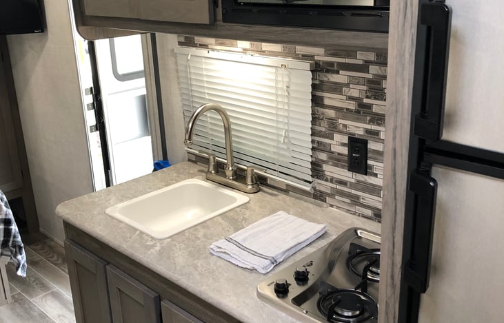 Kitchen sink and stove area, with storage cabinets