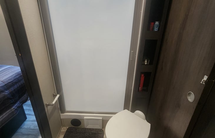 Bathroom equipped with mirror and sink, toilet and shower.  Two pocket doors allow for privacy.