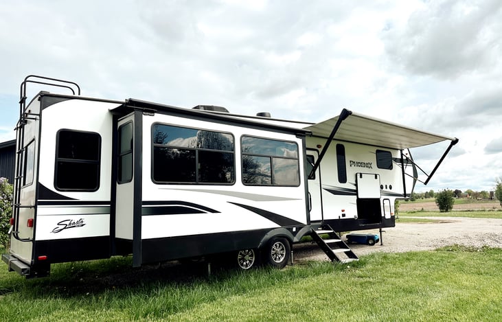 Passenger side exterior view.   Large living room slide and windows face your campsite.