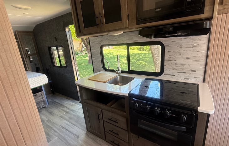 3-burner propane stove, Air-fry oven, 2-sided sink. Microwave over stove.