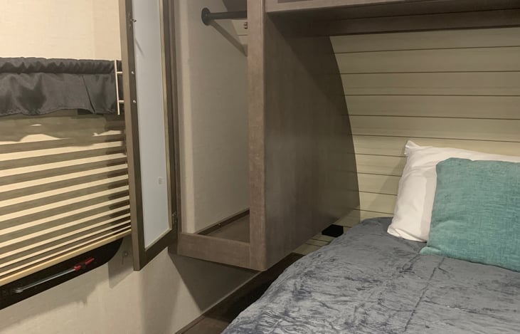 Storage with hanging rods on both sides of bed.