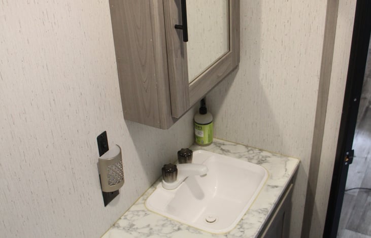 Bathroom area includes sink and mirror medicine cabinet.