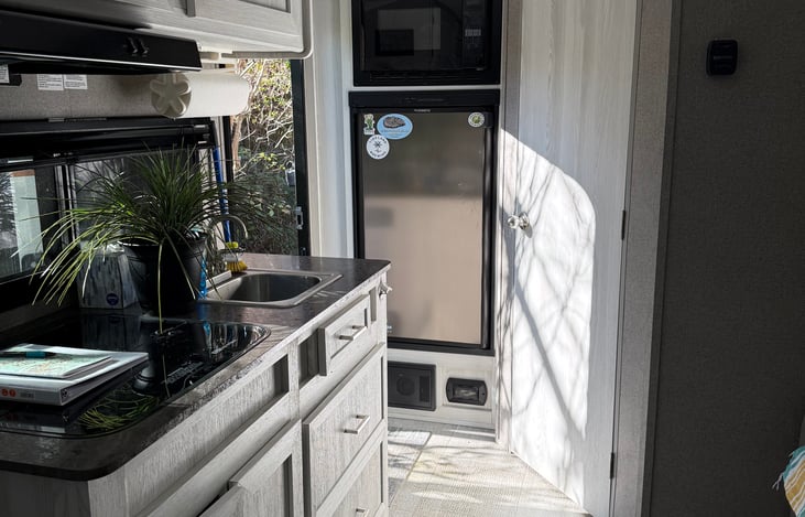Full kitchen with stovetop and convection oven with large fridge.