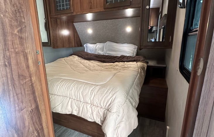 Private queen bed in master bedroom with plenty of storage and door for privacy.