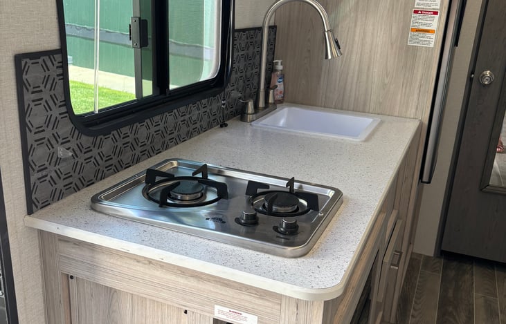 Kitchen with 2 burner stove and kitchen sink.