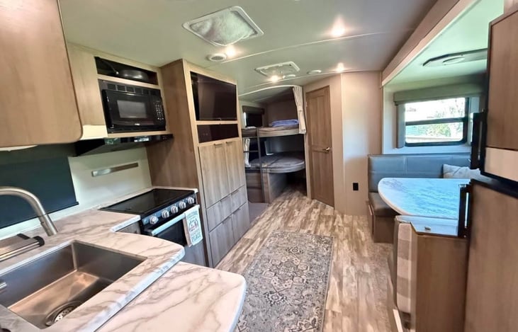 Full kitchen with microwave, oven, gas range, sink with hot and cold water, fridge and freezer.