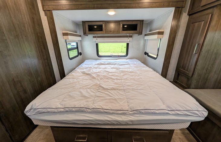 Private front bedroom features a walk-around Queen bed, TV, ample wardrobe storage, and a cozy built-in window seat nook—perfect for relaxing with a book! Full of natural light from 6 windows.
