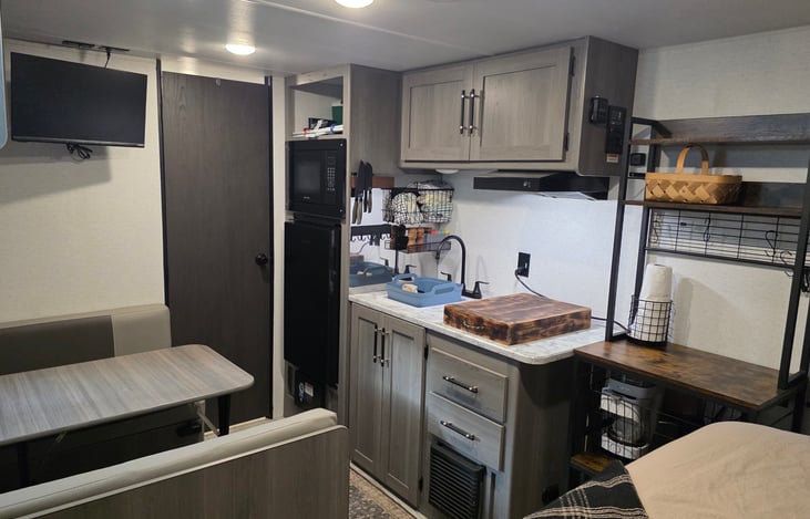Everything needed to cook indoors or outdoors. Outdoor propane grill, camp stove, microwave, propane stovetop, toaster, air fryer, coffee pot, and electric kettle. Tableware for 4.