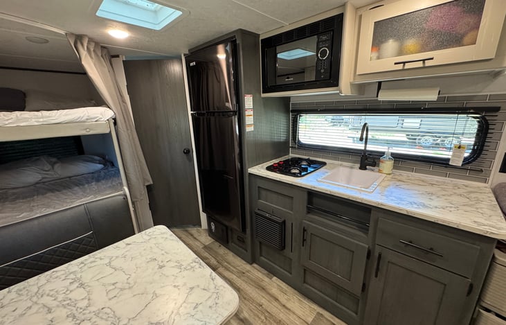 Kitchen has ample storage, sink, microwave, fridge and propane stovetop