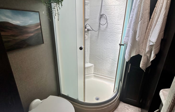 "Spacious Bathroom: Features a larger residential-style shower with skylight and modern finishes."