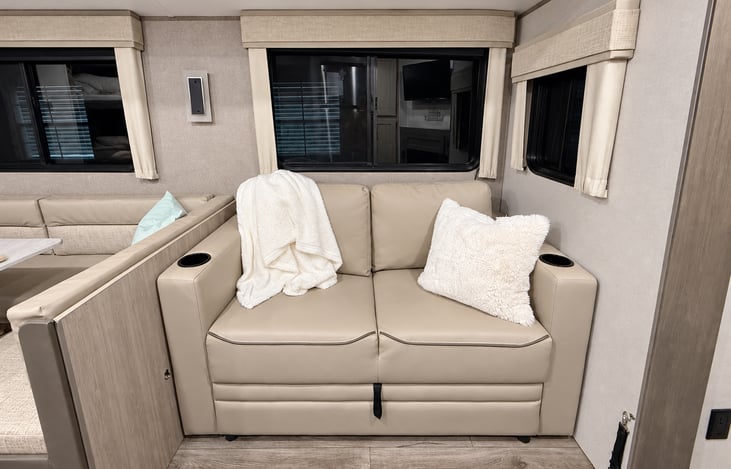 Comfortable sofa with a cozy fireplace and TV nearby — perfect for relaxing after a day of adventure.