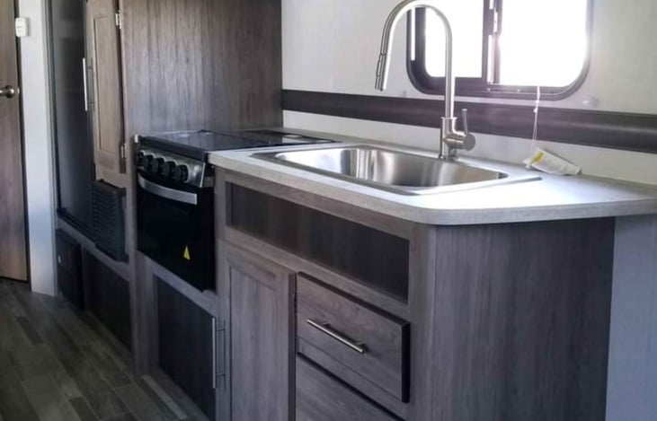 Kitchen has oven, burners, microwave and fridge.