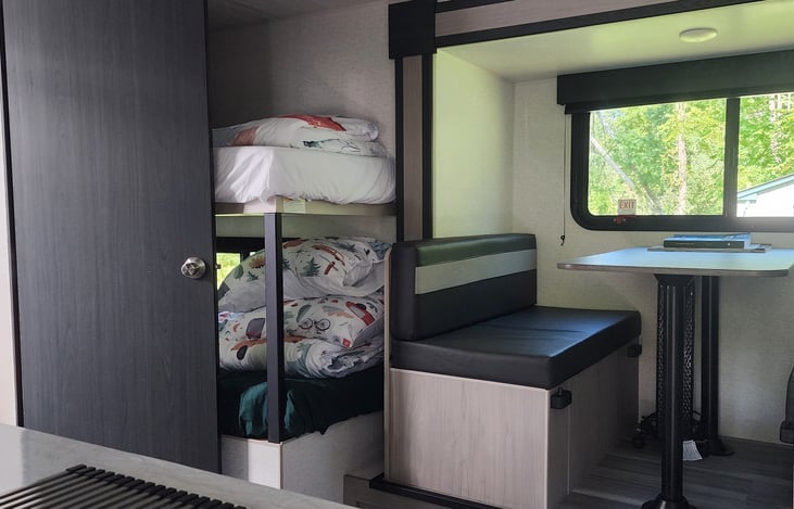 Bunk bed, dinette which converts to a bed (left seat: laundry stuff including laundry bags, toilette paper, paper towels, black tank pods/liquid, water filters, right seat: tool kits, level.)