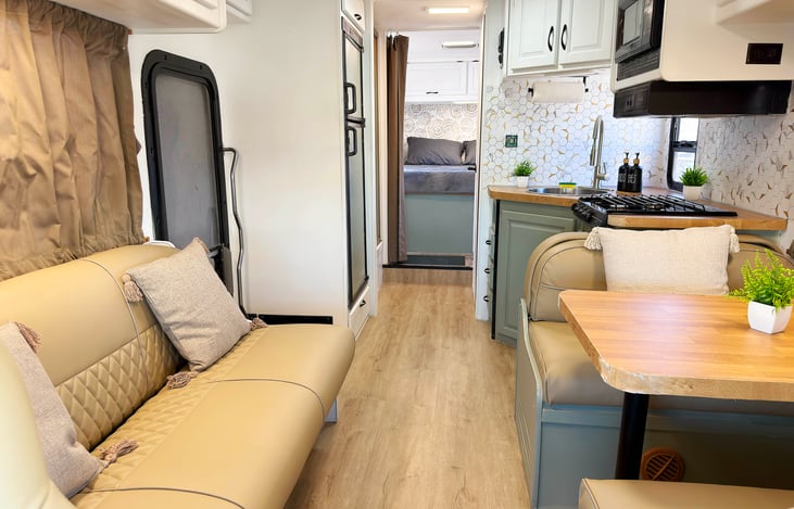 Share meals and laughs in this comfy dining nook — part of a glamping-style, event ready RV rental that sleeps 6 and offers a true home-on-the-road vibe