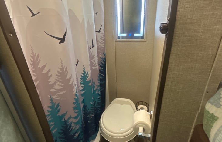 Bathroom stocked with toilet paper, shampoo, conditioner and body wash