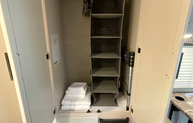 Closet with added closet organizer, hangers, and towels included. A drawer below for extra storage.