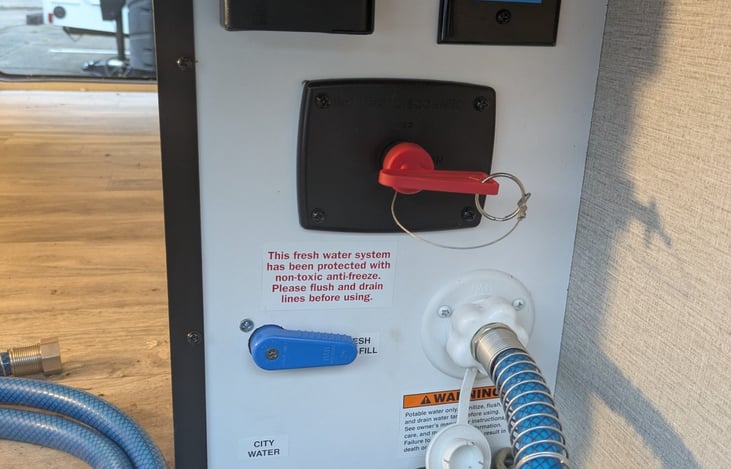 Easy access water hookups and battery disconnect switch.