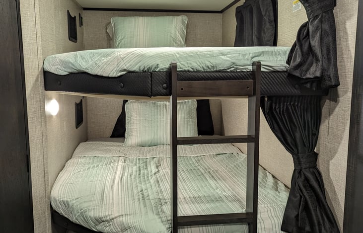 Full Size Bunkbeds with USB charging and Electrical outlets. Has a mesh pocket for holding electronics and lights.