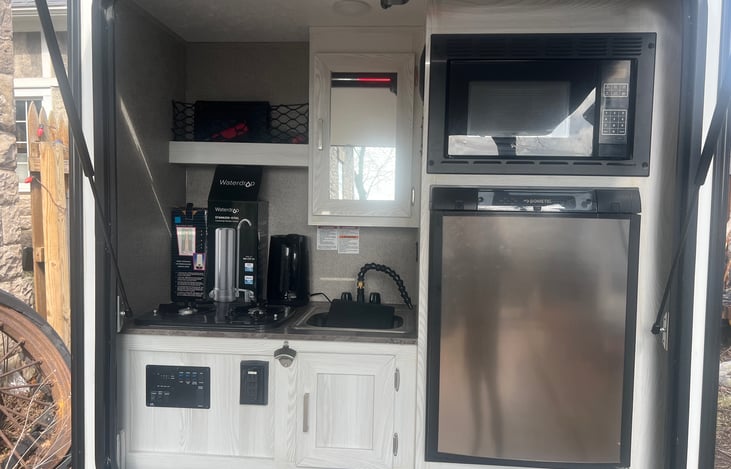 Full outdoor awning covered kitchen,  microwave, fridge, stovetop, sink, outdoor speakers