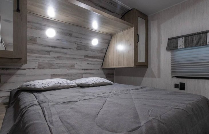 Queen bed in the front with storage closets and charging ports.  Master room also has doors on both sides that close.