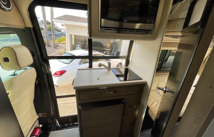 Compact and full of features, the galley includes a fridge freezer combo, large basin sink, induction cooktop and microwave.