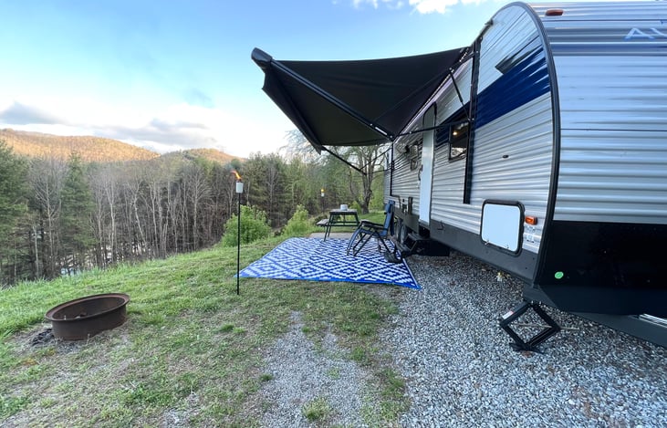 Outside of camper. Tiki torches and camping mat included. Guest supply their own tiki fuel if there is none in the canisters.