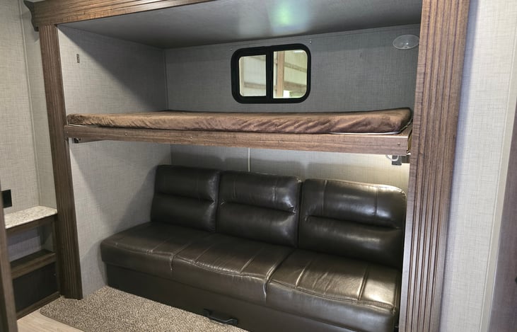 Upper bunk with collapsible couch underneath