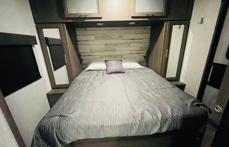 RV (short) Queen bed with storage underneath, on each side, and above.