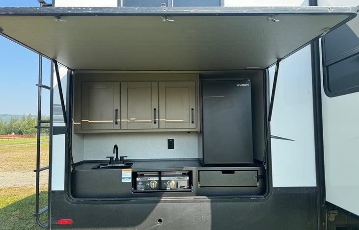 Outdoor kitchen with sink, fridge, and Capital Grill