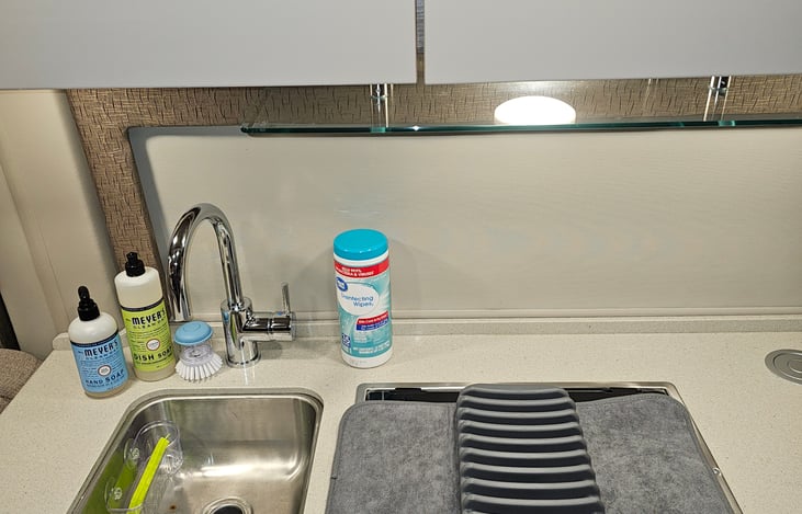 Dish and hand soap, sanitizing wipes, silicone sponge, scrubber and drying mat. Paper towels included but not in photo.