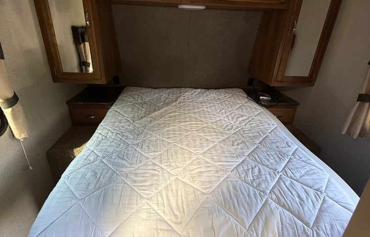 Will have new bedding, not pictured yet. Storage under the bed, on either side of bed, above bed, and bedside drawers too