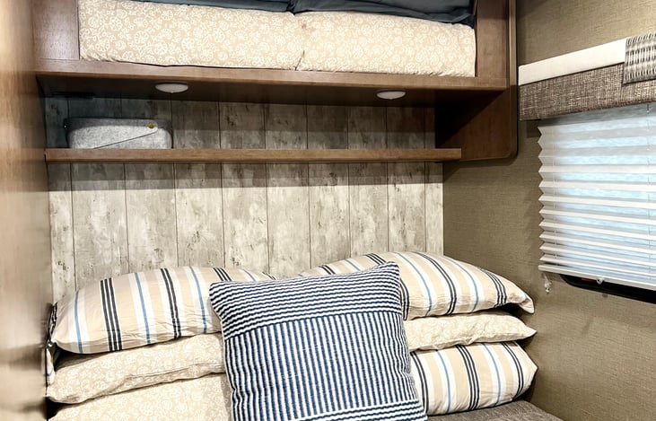 Extra bedding stored in cabinet above