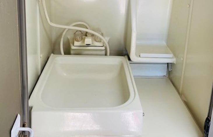 Fold down sink with medicine cabinet for toiletries.