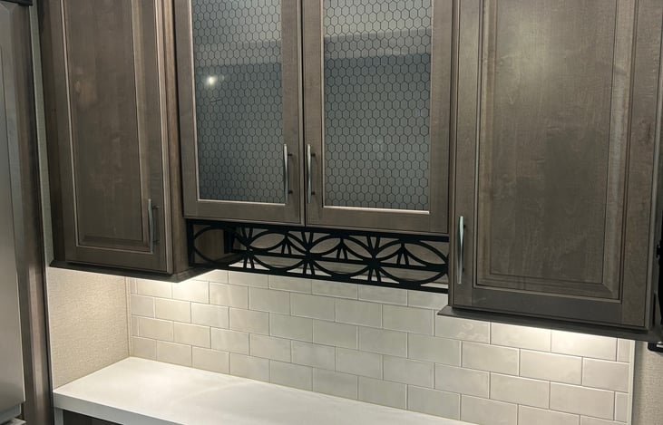 Kitchen counter with wine rack and under cabinet lighting.