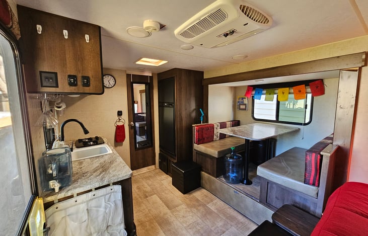 Dinette converts to additional sleeping space with storage underneath bench seats. 5 gallon filtered water provided with dispenser.