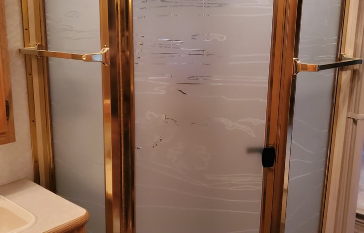 Glass shower door and vanity sink.