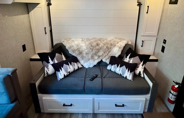 Modern queen Murphy bed featuring a built-in jackknife loveseat with cupholders that emerges when the bed is stored away.