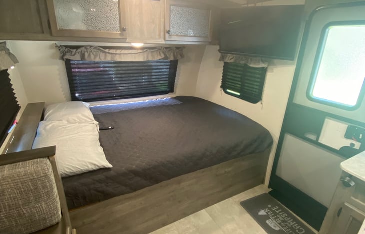 Queen bed with SmartTV on adjustable mount above.