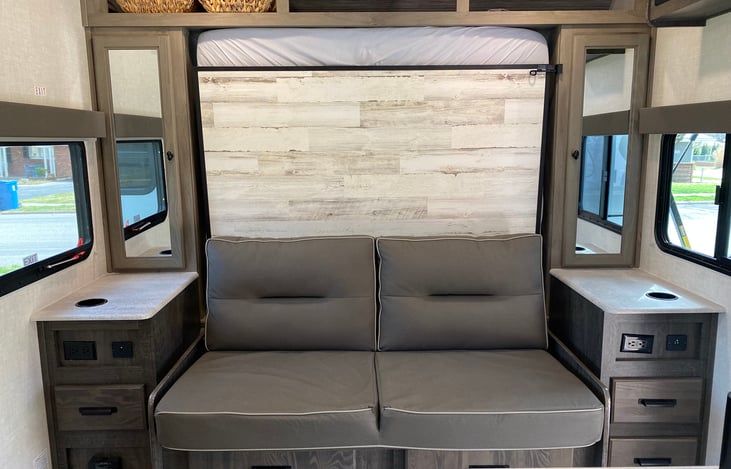 Easy to stow Murphy bed reveals couch for additional seating inside the camper.