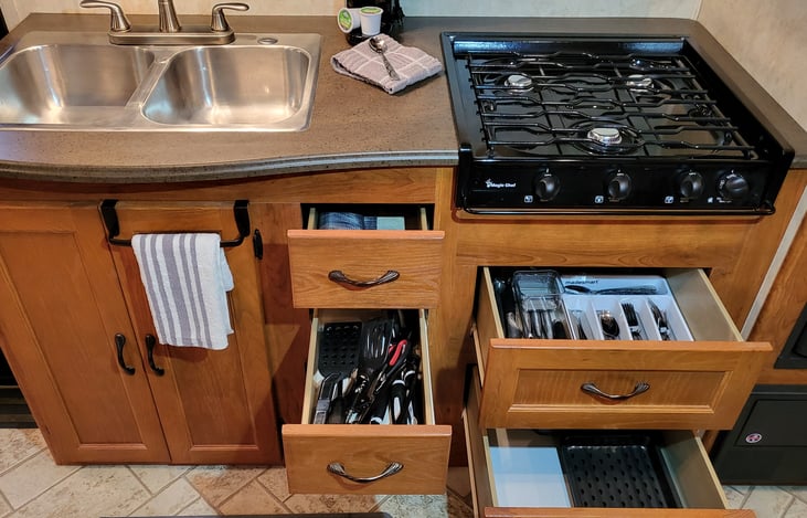 fully stocked with cooking utensils, cutlery, and kitchenware with excess storage still available to bring your own.