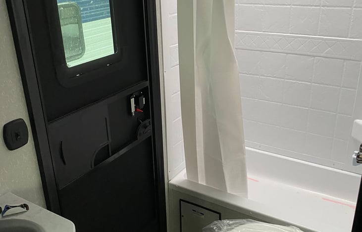 Bathroom with own outdoor entrance and a tub/shower