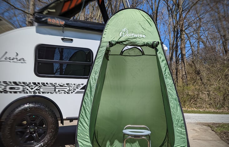 The Luna Rover comes with an OUTSIDE shower / toilet tent. The tent, toilet, and shower fold down. Shown is the toilet setup.
