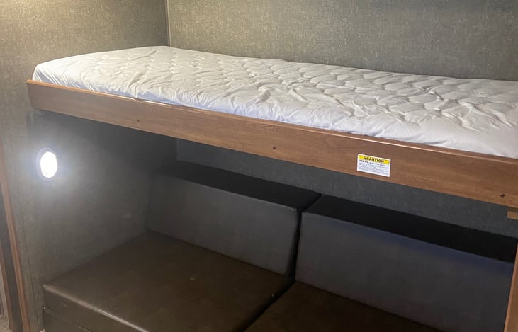 The bottom seating area folds out into a full-sized bed that can hold two guests, above it sits a single bed for additional sleeping space.